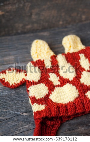 A handmade knitted giraffe hat on a wooden backgrond 