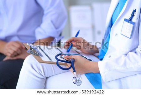 Doctor woman sitting with male patient at the desk Royalty-Free Stock Photo #539192422