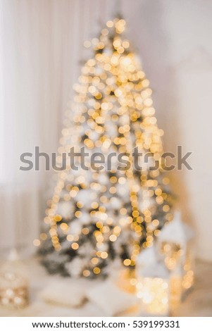 Blurred beautiful glowing Christmas tree in home interior. Vertical color photo
