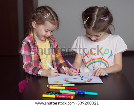 Happy cute kids draw  rainbows and write the word happiness,  small  artists paint  rainbow