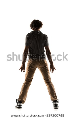 Young man dancer dancing funky hip hop rnb on isolated studio white background. Full length silhouette.