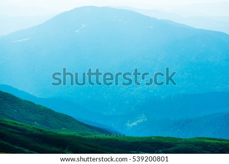 Abstract mountain background - concept of tourism and mountaineering. Layers of ridges in Carpathians Mountains Ukraine at sanrise sky