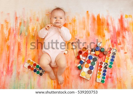 Beautiful child  draws bright colors on an abstract background