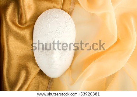 Carnival mask lies on the golden tissue