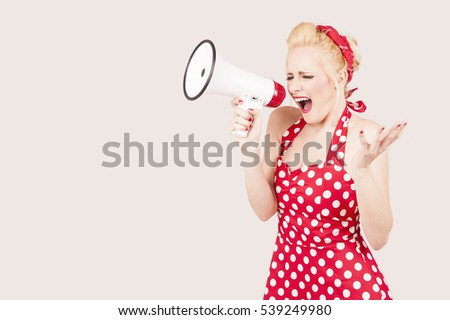  woman screaming on a megaphone and dressed in pin-up style red dress 
