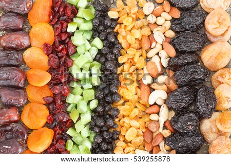 Dried fruit background. Rows of dried dates, apricots,cranberries, pomelos, blueberries, nuts, prunes and figs. Royalty-Free Stock Photo #539255878