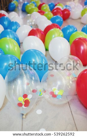 Colorful balloons lie on white floor