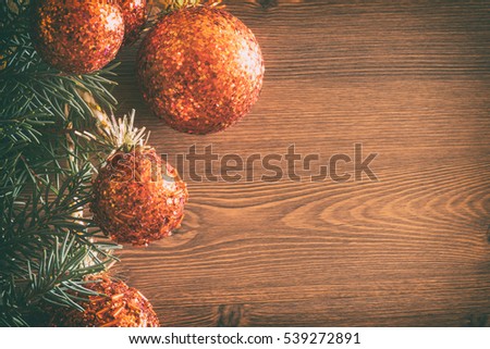 Christmas or new year background with fir tree branches and decorations of orange balls on wooden table. Flat lay with copy space