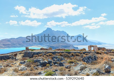 Aerial panoramic view through stone wall of an ancient Venetian castle on the lovely rocks and beach at Balos bay ( famous landmark ). Island of Imeri Gramvousa next to Crete. Chania. Greece. Europe