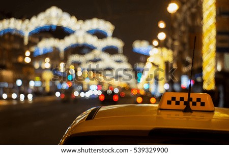 Christmas taxi in night city. Festive city lights.