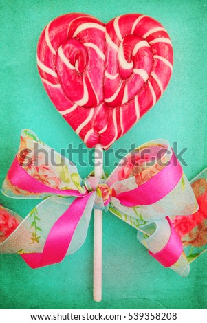 Heart shaped lollipop for Valentine's Day with turquoise copy space background