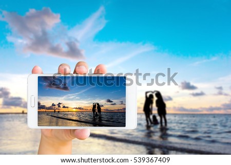 Mobile phone, blur image of the beach at Phuket Island,Thailand on screen and  background.