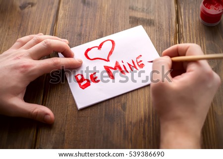 On a white sheet, vintage background, with red paint men's hand-written greetings with Valentine's day