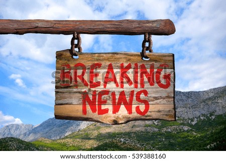 Breaking news phrase sign on old wood with blurred background