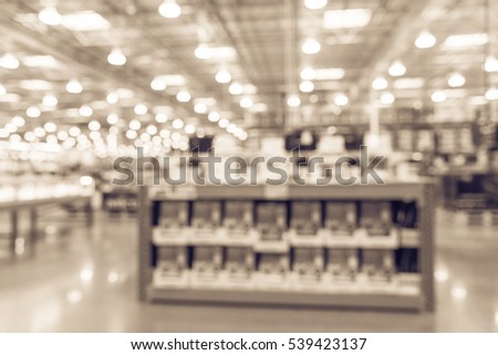 Blurred variety of modern digital DSLR on display at camera department in distribution warehouse or storehouse. Defocused background of inventory, hypermarket, wholesale bokeh light. Business concept