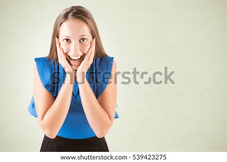 Young woman looking surprised, isolated in a green background