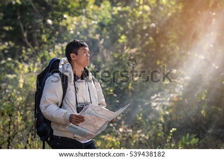 Young tourists with maps and backpack in the forest. hot sun.