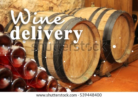 Wine barrels in cellar. Text WINE DELIVERY on background