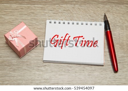 Gift box and notebook with message on desk