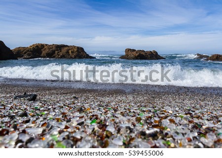 colorful glass pebbles blanket this beach in Fort Bragg, California, photo taken mid day to get bright color in the rocks and water