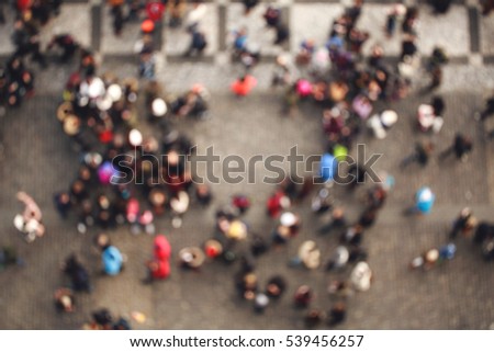Blurred crowd of people in multicolored clothes in the city. Top view
