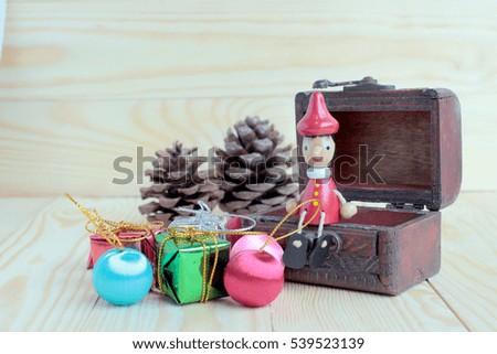 Christmas background with the wood boy doll, snowman, decorations and gift boxes on rustic wooden board with copy space