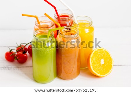 Fresh detox juices in glass bottles on white background