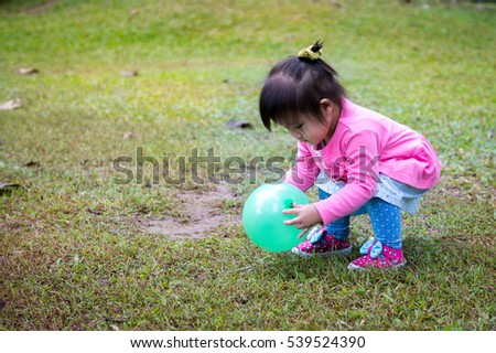 Picture of child development of 2 year and 2 months baby playing  in the garden : For concept such as happy kid, learning, play and exploration.