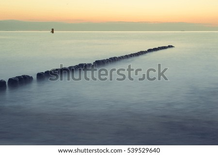 Breakwaters in the Baltic sea over the sunset in summer