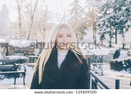 Young pretty blonde gril in city winter park