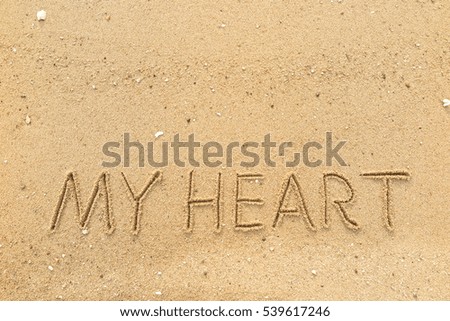 Handwriting words "MY HEART" on sand of beach