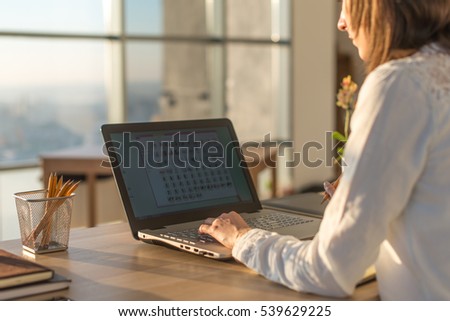 Female writer typing using laptop keyboard at her workplace in the morning. Woman writing blogs online, side view close-up picture.