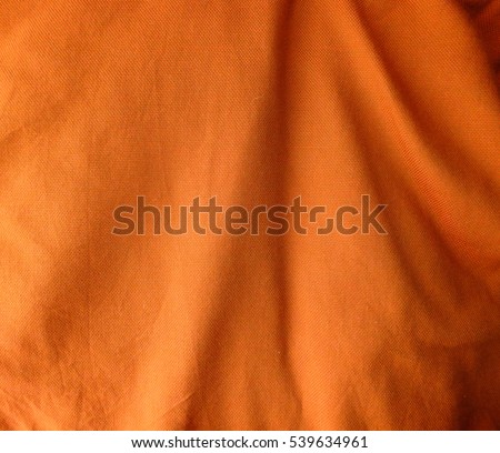 Orange fabric folds background Royalty-Free Stock Photo #539634961