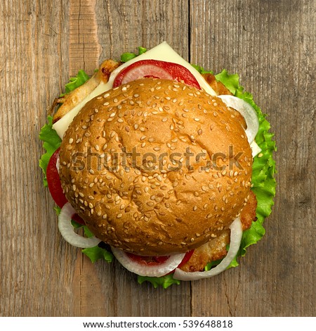 Top view delicious hamburger on wooden background. Fastfood meal Royalty-Free Stock Photo #539648818