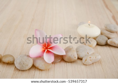 Pink Frangipani flower with pebbles ,candle on wooden background
