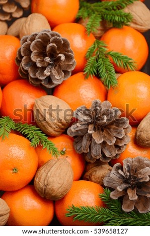Fresh tangerine clementine with nuts and cones, selective focus, vertical.