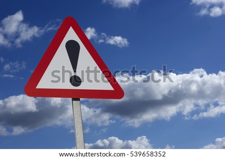 RED AND WHITE ROAD TRAFFIC WARNING SIGN WITH BLACK EXCLAMATION MARK AND BLUE SUMMER SKY Royalty-Free Stock Photo #539658352