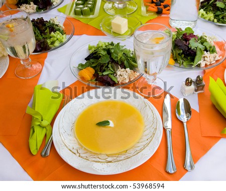 An inviting table is set beautifully and colorfully with nice dishes and a healthy meal.