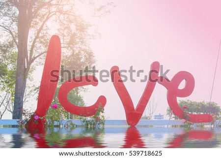 Red love lettering on nature background