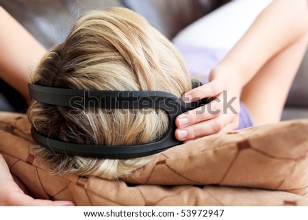 Smiling woman using a remote in the living-room