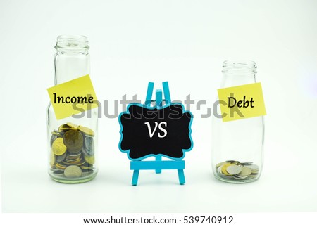 Debt vs Income text written on glass jar. Business or Financial concept.