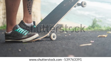 Closeup of skateboarder legs. Man riding skateboard outdoor.	