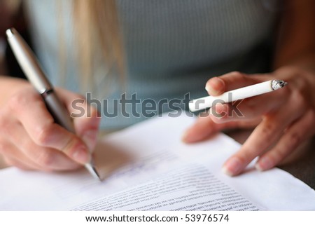 Young woman with cigarette in hand signs contract
