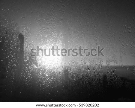 Raindrops on silver glass surface. Natural Pattern of rain drops on wet window monochrome