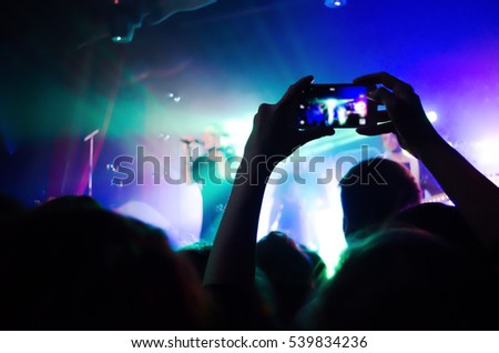 Video recording of the concert on the phone a smartphone. Reggae colors.