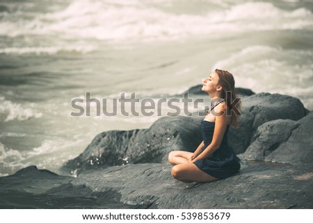 Woman Enjoy the Nature and meditate on the big Stone. Good air concept. Freedom.  Royalty-Free Stock Photo #539853679