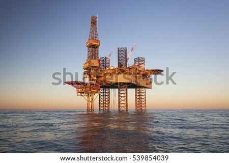 Offshore Jack Up Rig in The Middle of The Sea at Sunset Time Royalty-Free Stock Photo #539854039