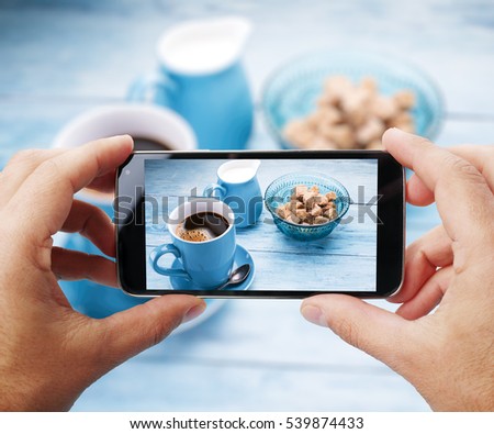 Taking photo of cup of coffee by smartphone. Closeup view of  process. File contains clipping paths for smartphone and hands and  picture on it.