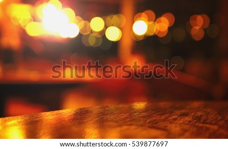 blur top of wood table at pub with bokeh light in the dark night background Royalty-Free Stock Photo #539877697