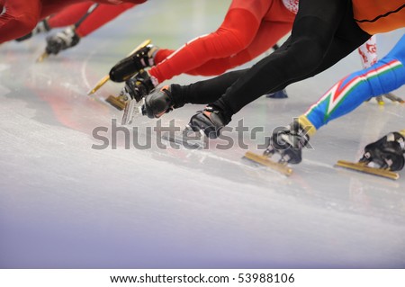 A close-up of the legs of ice-skaters in a race.